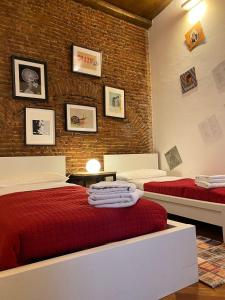 a bedroom with two beds and a brick wall at Kindness art apartment in historic center in Arona