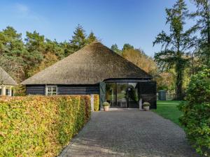 ein Gebäude mit einem Strohdach und einer Auffahrt in der Unterkunft Landhuis de Vos in Gouwelaar