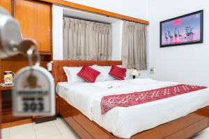 a bedroom with a large bed with red pillows at Hotel Green Field in Satara
