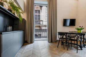 una cucina e una sala da pranzo con tavolo e sedie di Ferrini Home - Etnea Portrait a Catania