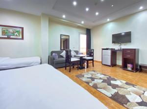 um quarto com uma cama e uma sala de estar em Best View Pyramids Hotel em Cairo