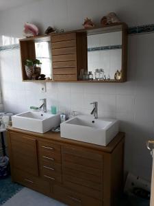- une salle de bains avec deux lavabos sur un comptoir en bois dans l'établissement Chambre dans jolie demeure, à Gouesnou