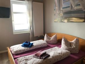 two beds with pillows on them in a bedroom at Hotel & Restaurant Neptun in Norddorf
