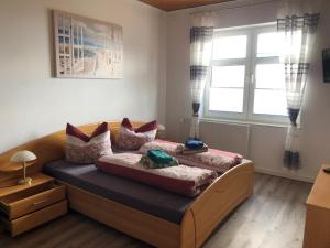 um quarto com uma cama com almofadas e uma janela em Hotel & Restaurant Neptun em Norddorf