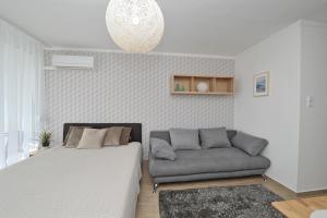 ein Schlafzimmer mit einem Bett und einem Sofa in der Unterkunft BELLAPARTMAN in Balatonfüred