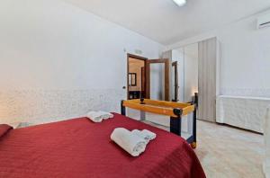 ピモンテにあるAppartamento Lattariのベッドルーム1室(赤いベッド1台、タオル付)
