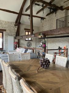 a dining room with a wooden table and chairs at Le Clos Bô-m in Marignieu