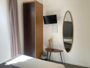 a bedroom with a bed and a mirror and a table at Day Off Suite&Hostel in Setúbal