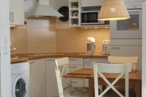 eine Küche mit einer Waschmaschine, einem Tisch und Stühlen in der Unterkunft Ostsee-Apartment "Weite Welt" in Kiel
