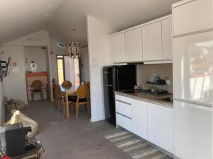 a kitchen with white cabinets and a dining room at Day Off Suite&Hostel in Setúbal