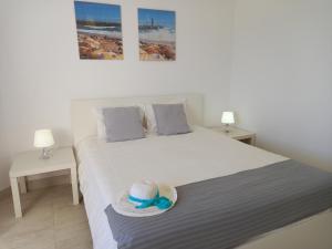 a bedroom with a bed with a hat on it at Torre Azul 11 Vista Panoramica in Quarteira