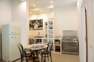 a kitchen with a table and chairs and a refrigerator at The Old Bakery in Cagliari