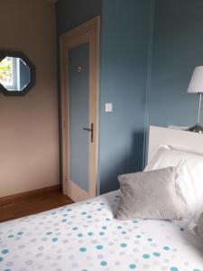 a bedroom with a bed with a blue wall and a door at Chambre dans villa in Gouesnou