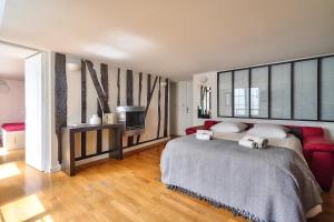 - une chambre avec un grand lit et un canapé rouge dans l'établissement The Perfect Parisian 2 bdrs flat at Le Marais, à Paris