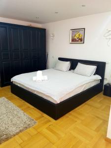 een slaapkamer met een bed met een zwart hoofdeinde bij Apartament Gomoiu Monza Arena Nationala in Boekarest