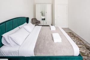 a large bed with a green headboard in a bedroom at Avangard on Shevchenko Avenue 25 Apart in Lviv