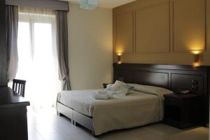 a bedroom with a bed with two towels on it at Albanuova Hotel in Reggio di Calabria