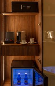 a fish tank in a cabinet with a microwave and cups at SH Suite Palace in Valencia