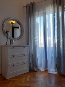 een wit dressoir met een spiegel en een raam bij Apartments M GREGOR ideal for relaxing holidays in Baška