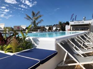 a swimming pool with two lounge chairs on a balcony at Delamar 4*Sup-Adults only (18+) in Lloret de Mar