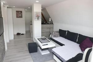 ein Wohnzimmer mit einem Sofa und einem Tisch in der Unterkunft Apartmani Zlatarski DAR in Nova Varoš