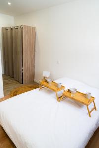 1 dormitorio con 2 mesas en la parte superior de una cama en Spacieux appartement proche centre-ville en Saumur