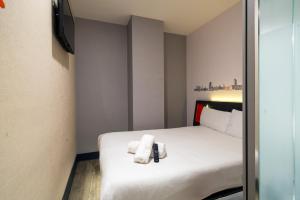 a hotel room with a bed with towels on it at easyHotel Oxford in Oxford