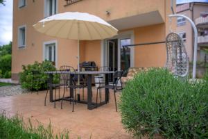 a patio with a table and chairs and an umbrella at Crni mačak in Matulji