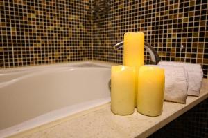 a yellow candle sitting on top of a bath tub at Talmud Hotel Tainan in Tainan