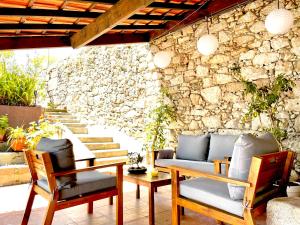 a patio with chairs and a table and a stone wall at Look At Me - Serviced Lofts & Studios in Porto