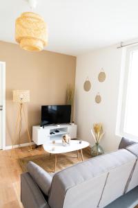 a living room with a couch and a table at Spacieux appartement proche centre-ville in Saumur