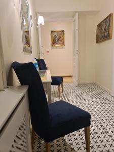 a waiting room with a blue chair and a desk at Amber Hostel in Krakow