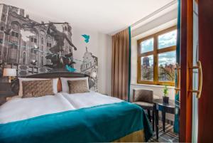 Schlafzimmer mit einem Bett, einem Schreibtisch und einem Fenster in der Unterkunft Hotel Hanza in Danzig