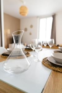 un jarrón de cristal sobre una mesa en Spacieux appartement proche centre-ville en Saumur