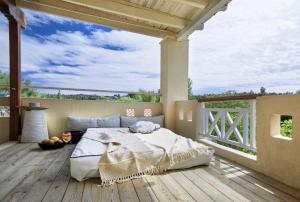 a bedroom with a bed on a wooden deck at Sanidiamonds in Sani Beach
