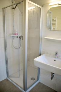 uma casa de banho com um chuveiro e um lavatório. em Hotel Garni Meeresblick em Glowe