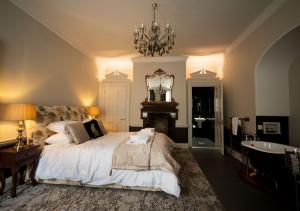 a bedroom with a large bed and a chandelier at East Walls Hotel in Chichester +26 photos