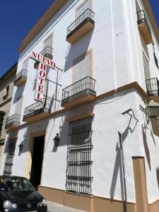 a building with a hotel sign and a car parked in front at Nuevo Hotel in Jerez de la Frontera