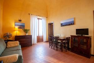 un soggiorno con un divano e un tavolo con una televisione di Castello di Populonia VILLA A MARE a Populonia