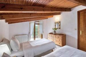 a bedroom with two beds and a wooden ceiling at Sanidiamonds in Sani Beach