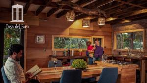 a woman holding a child in a kitchen with a table at Casa del Faro Chiloé in Castro