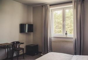 1 dormitorio con cama, ventana y mesa en Hotel Dwa Księżyce, en Toruń
