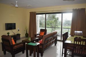 a living room with a couch and chairs and a table at Status Homeaway Service Apartments in Nashik