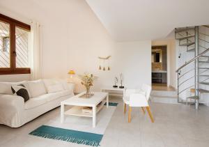 a white living room with a white couch and a table at Sanidiamonds in Sani Beach