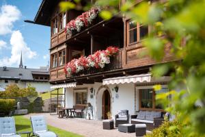 un edificio con flores a un lado. en Garni Hotel Geier, en Santa Cristina Valgardena