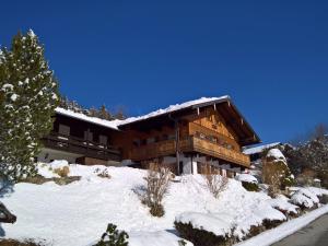 a large wooden building with snow on the ground at Haus Tauernblick in Berchtesgaden