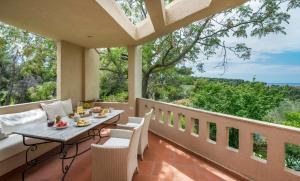 a patio with a table and chairs on a balcony at Sanidiamonds in Sani Beach