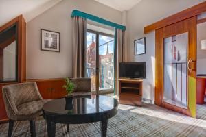 a living room with a table and a tv at Hotel Hanza in Gdańsk