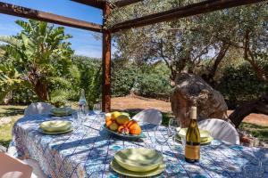 a table with a plate of fruit and a bottle of wine at Deliziosa Villa a 500 metri dal mare con Piscina in Terrasini
