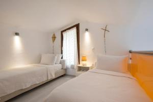two beds in a room with a window at Sanidiamonds in Sani Beach